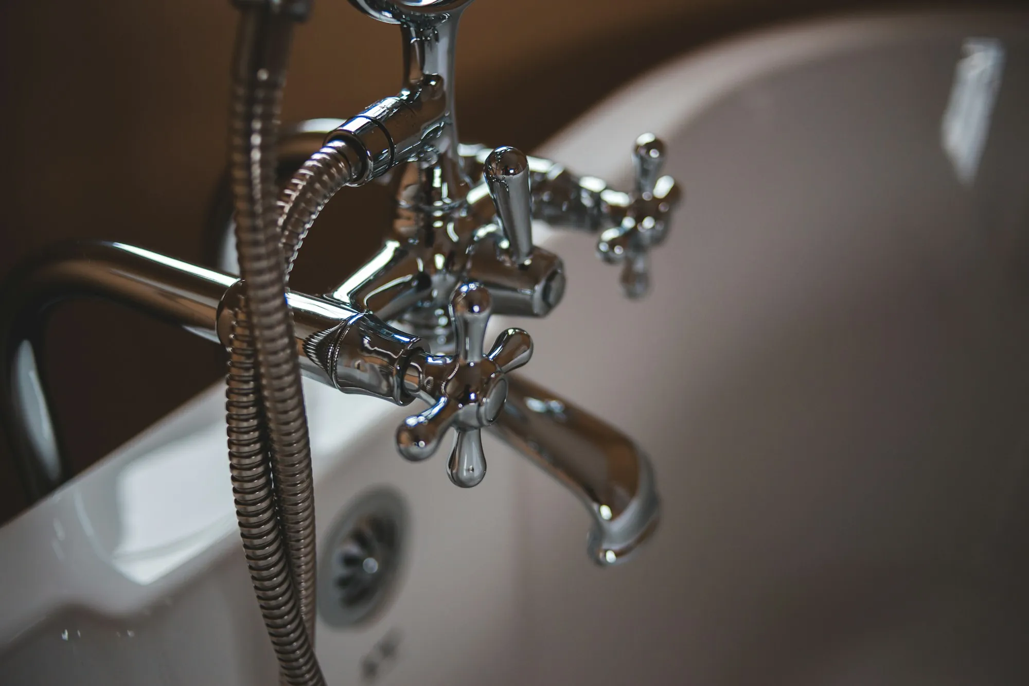 Under-sink drinking water filters in Laguna Hills Chrome faucet with a hose over a white ceramic sink