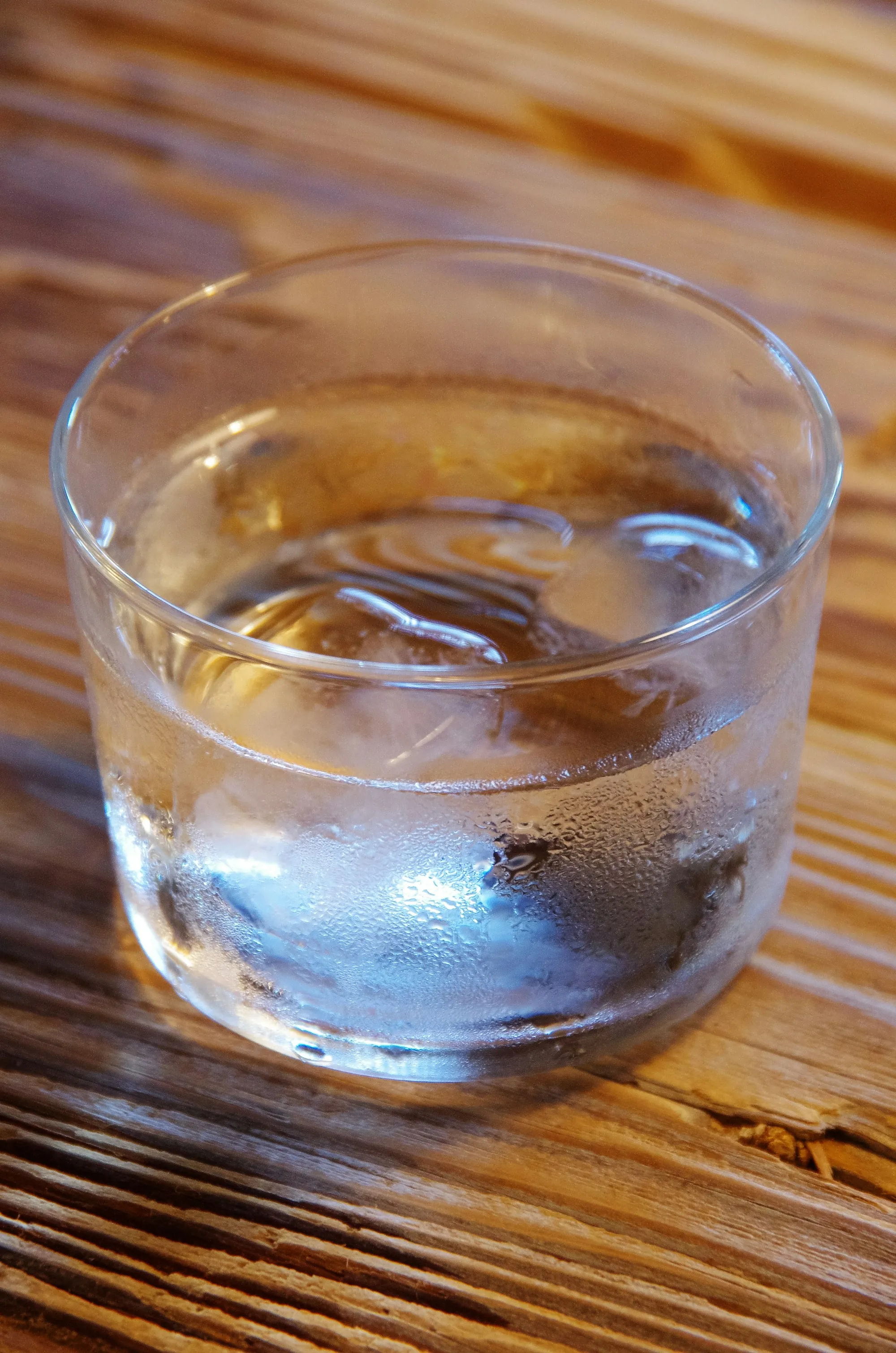 Book a water test in Laguna Hills Glass of cold water with ice cubes on a wooden table