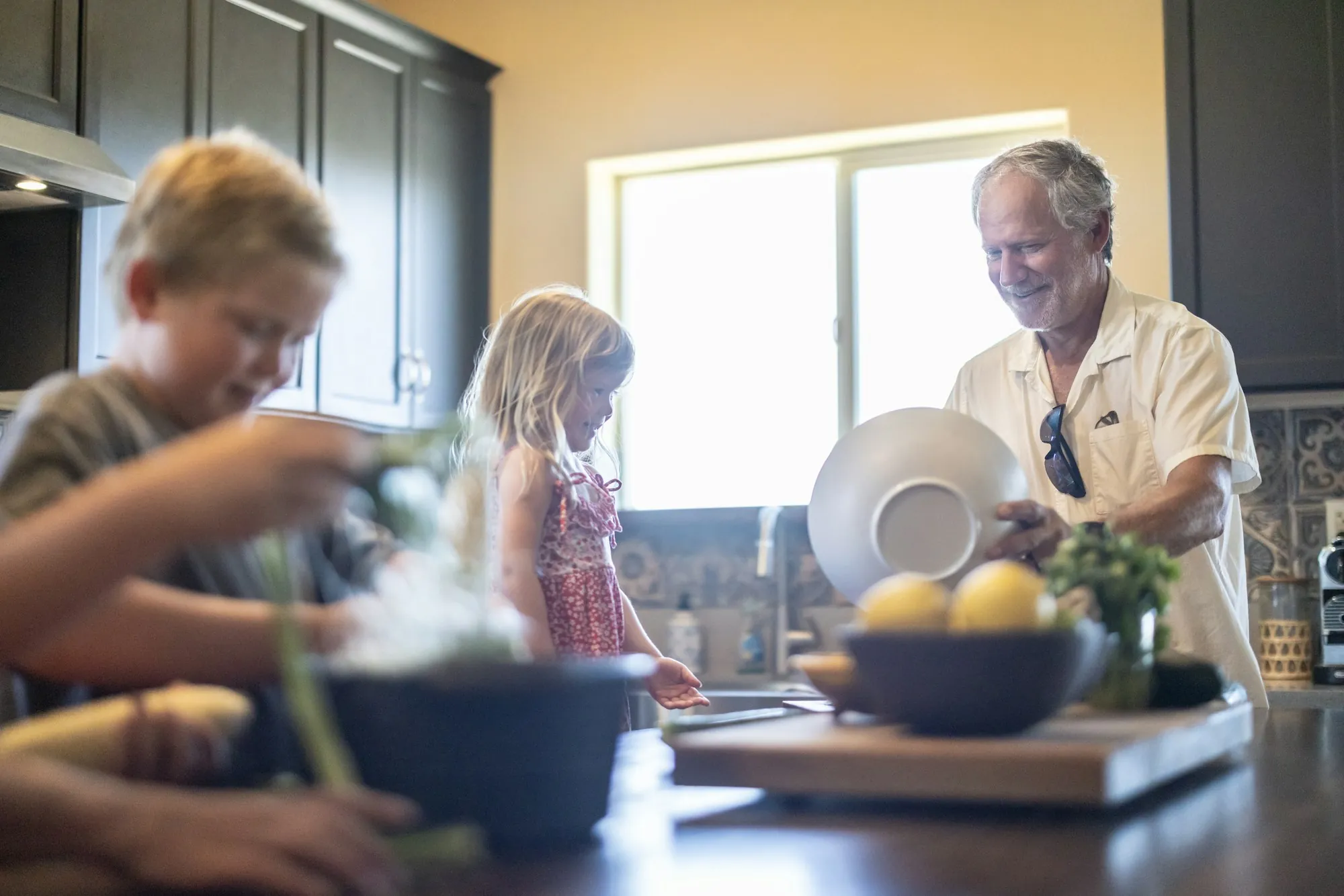 Local water specialists in Laguna Hills Grandfather and grandchildren preparing food in a home kitchen