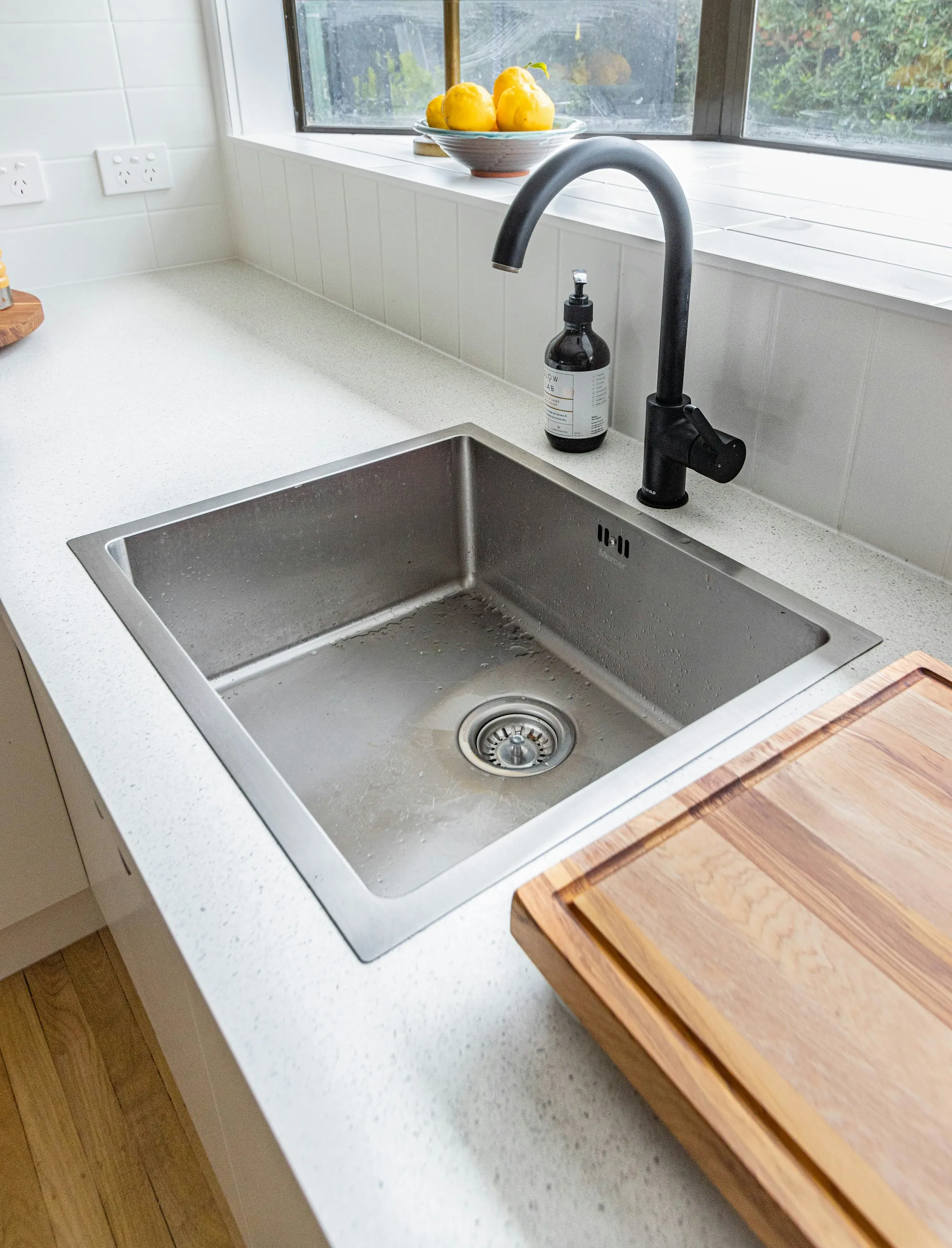 Why Laguna Hills homeowners call us first Stainless steel kitchen sink with a black faucet on a white counter